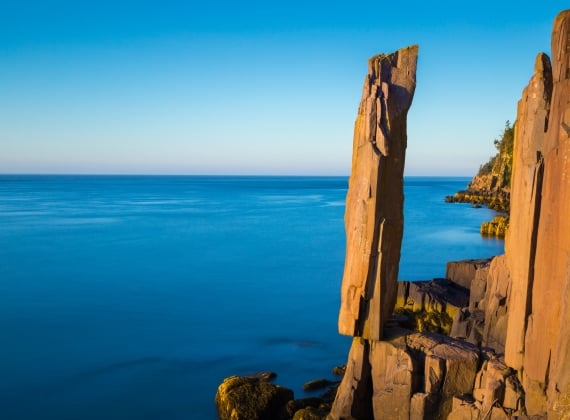 A jagged rock face on the edge of the ocean