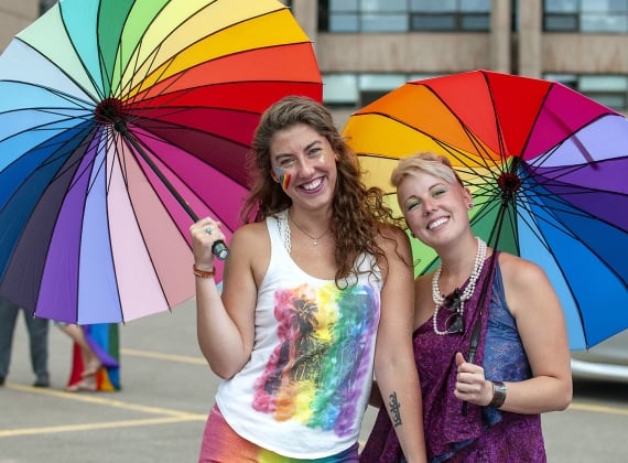 two-women-holding-rainbow-umbrellas