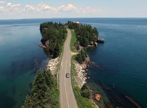 A narrow road on a land bridge with ocean on either side