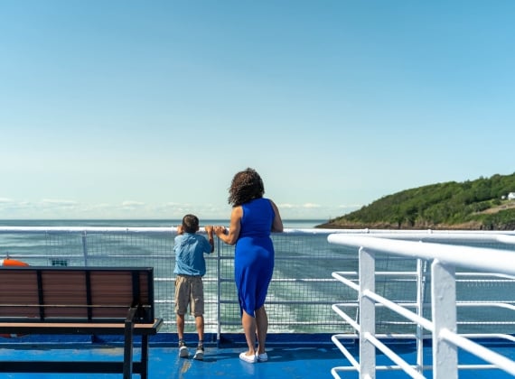 A mother and son look out over the railing on the MV Fundy Rose