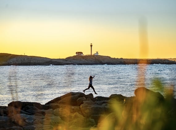 girl-jumping-off-rocks-at-cape-forchu-lighthouse