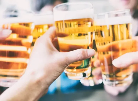 Numerous hands toasting with glasses of beer