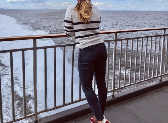 A woman looks out over the railing of the ferry