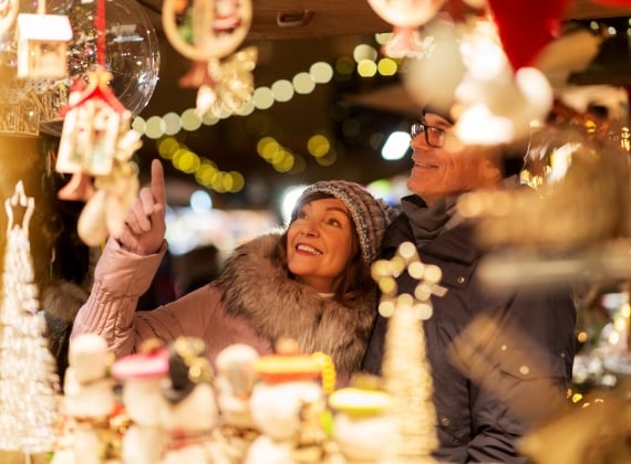 Senior couple at christmas market souvenir shop - stock photo