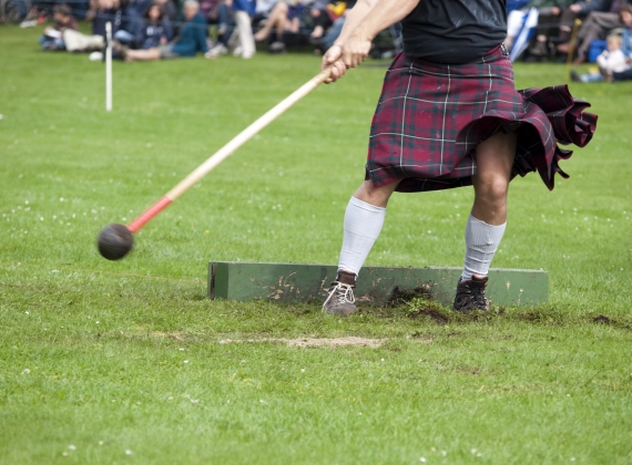 man playing cricket in a kilt