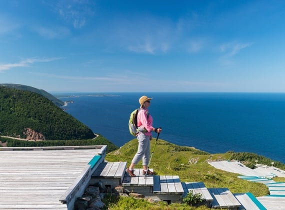 A woman hikes down a stairwell on the Cabot Trail