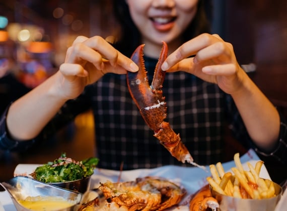 A person cracking a lobster claw