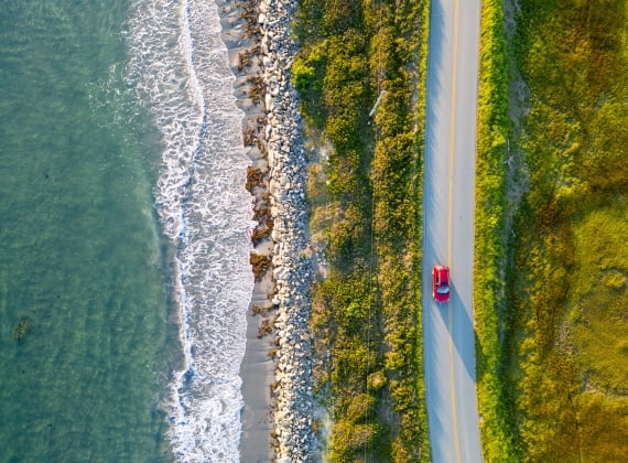 car driving on a road next a beach