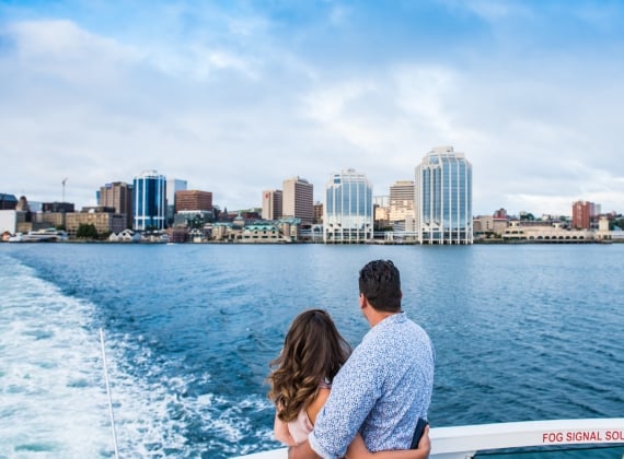 A couple arm in arm, rides the ferry to Dartmouth