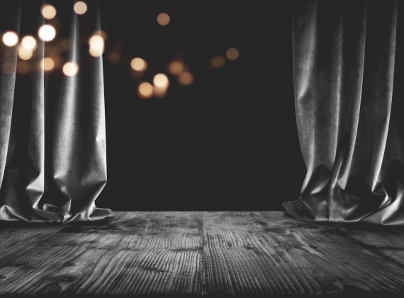 Dark curtains half-drawn on an empty stage