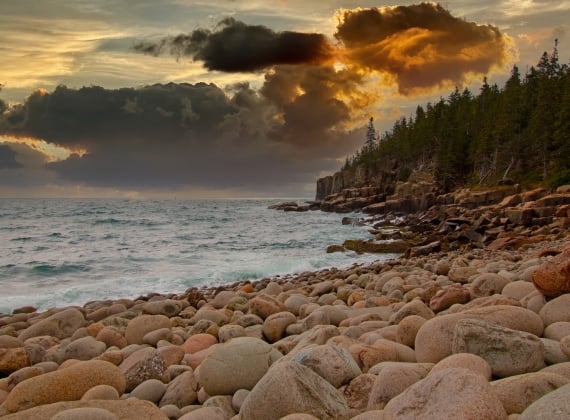 A beach under an orange sky at sunset in Bar Harbor