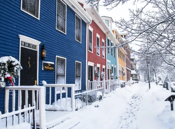 A snowy residential street in Charlottetown with footprints in the snow.