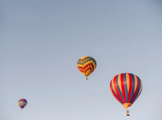 Three colourful hot air balloons in the sky