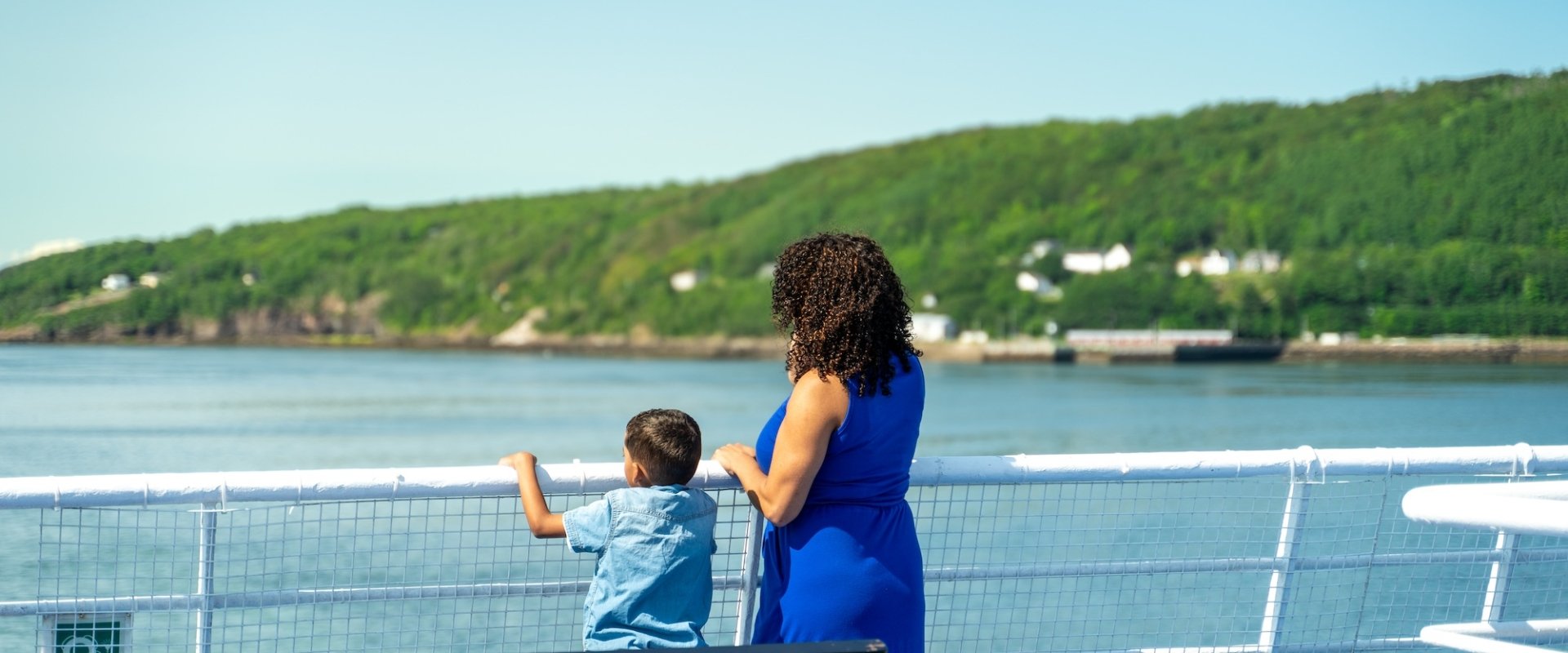 A mother and son look out over the railing on the MV Fundy Rose