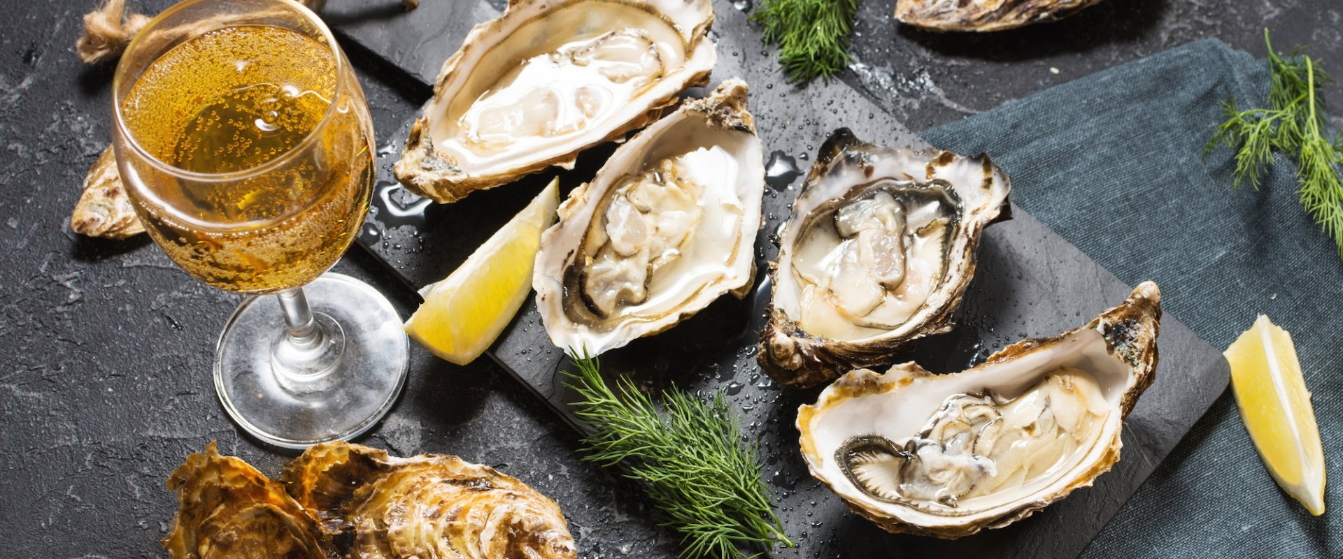 A plate of fresh oysters accompanies by a glass of wine